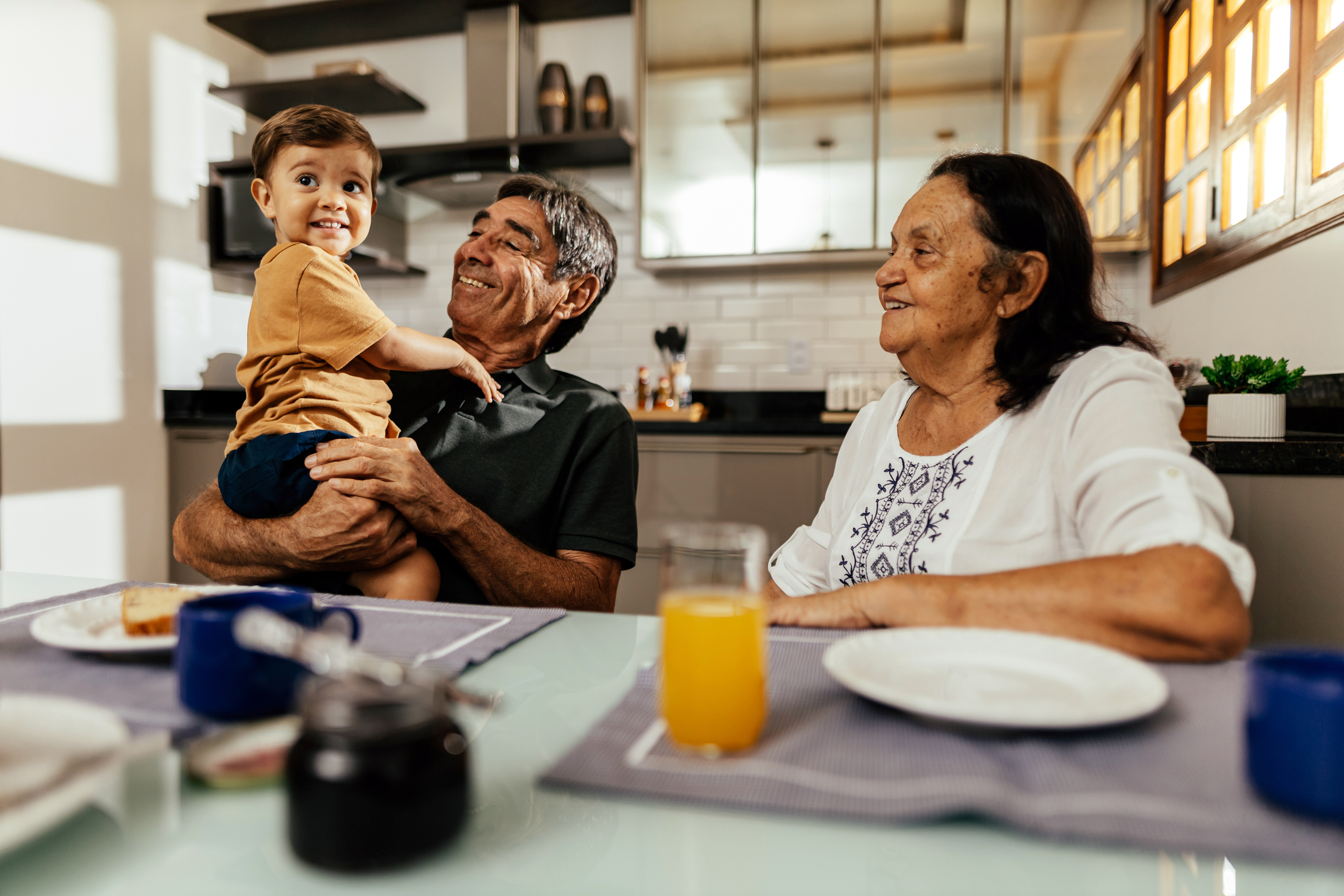 Happy grandparents having breakfast with their grandson