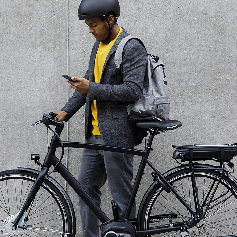Man checking phone standing near a cycle